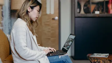 woman sitting on couch on her laptop