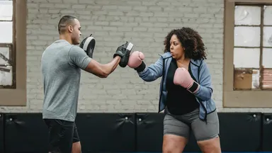 man and woman boxing in gym