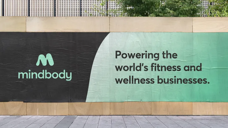 Out of home wheat pasting featuring the Midbody logo and a tagline that says "Powering the world's fitness and wellness businesses."