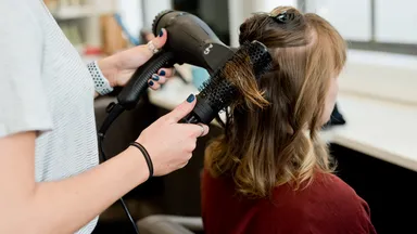 woman getting hair blown out at salon