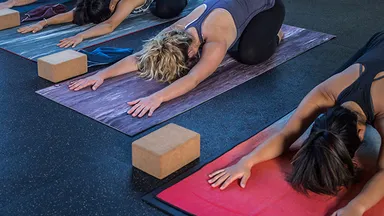 women in poses on yoga mats