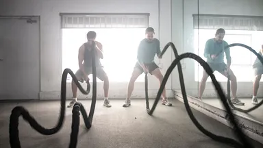 3 men work out using battle ropes