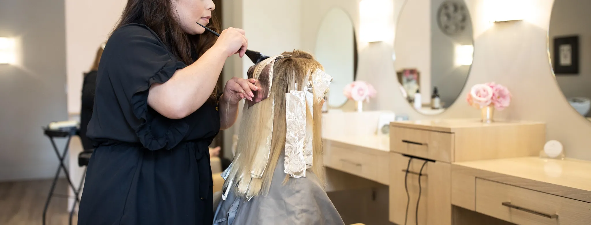 Hair stylist colors a woman's hair