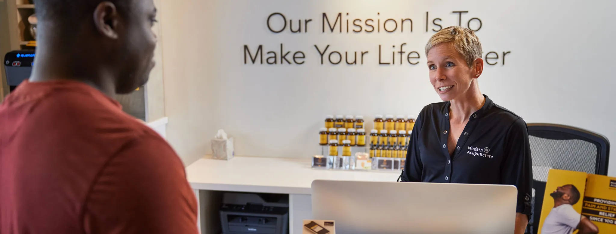 male customer at front desk of wellness business 