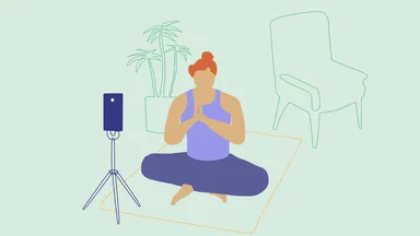 Woman live streaming a yoga class in front of a phone on a tripod