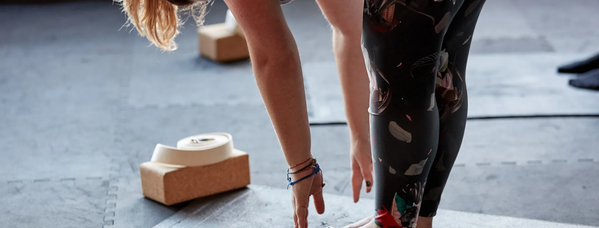 Woman stretching on a yoga mat with props in the background