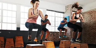 People doing box jumps in gym