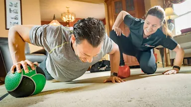 A GYMGUYZ coach teaching push ups