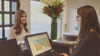 Woman helping a client at the front desk.