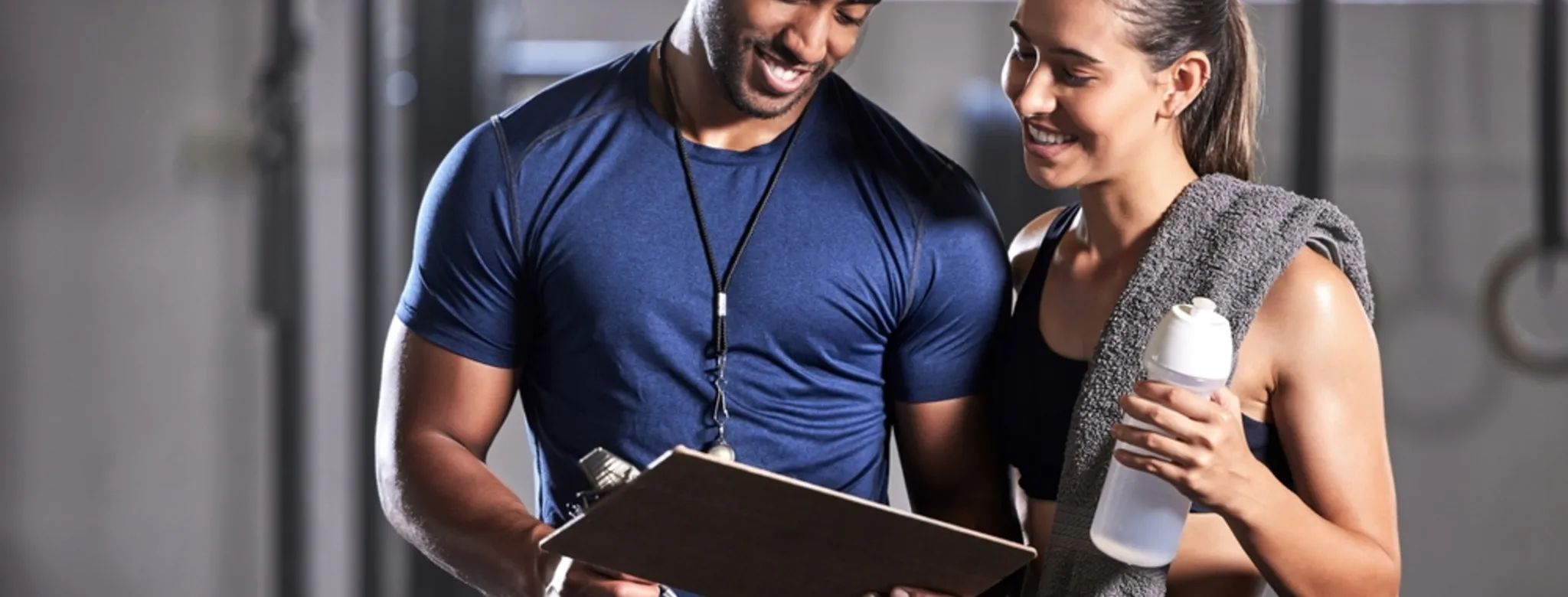 Instructor showing information to a female member at a gym