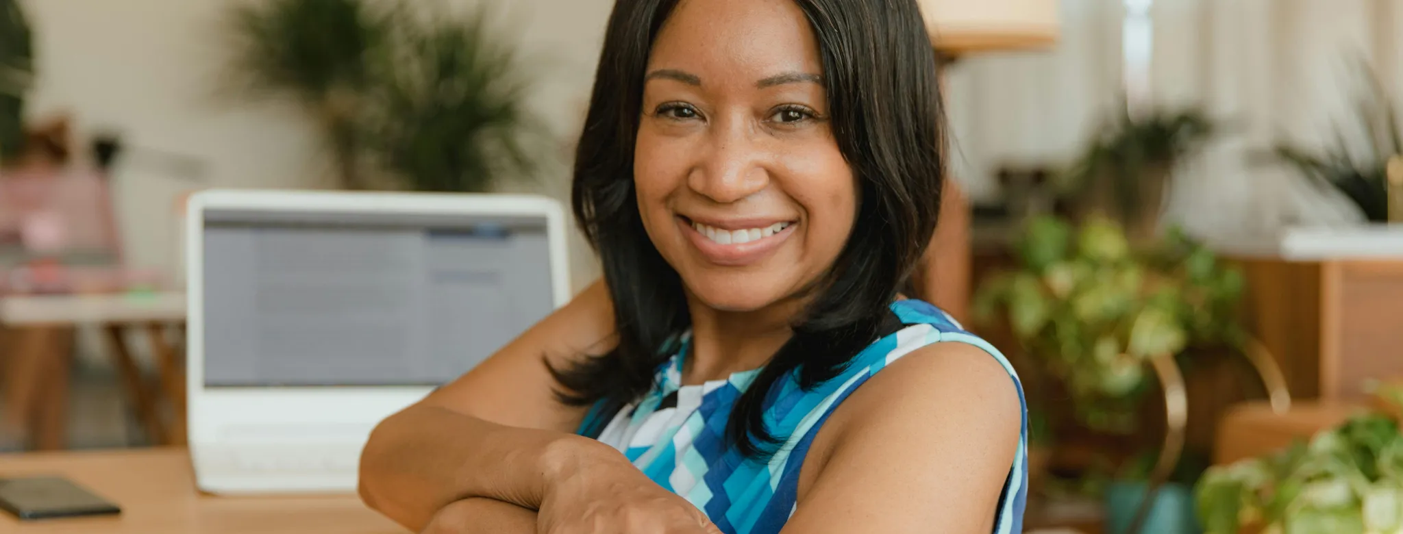 Business owner sitting in chair near computer using Mindbody Payments
