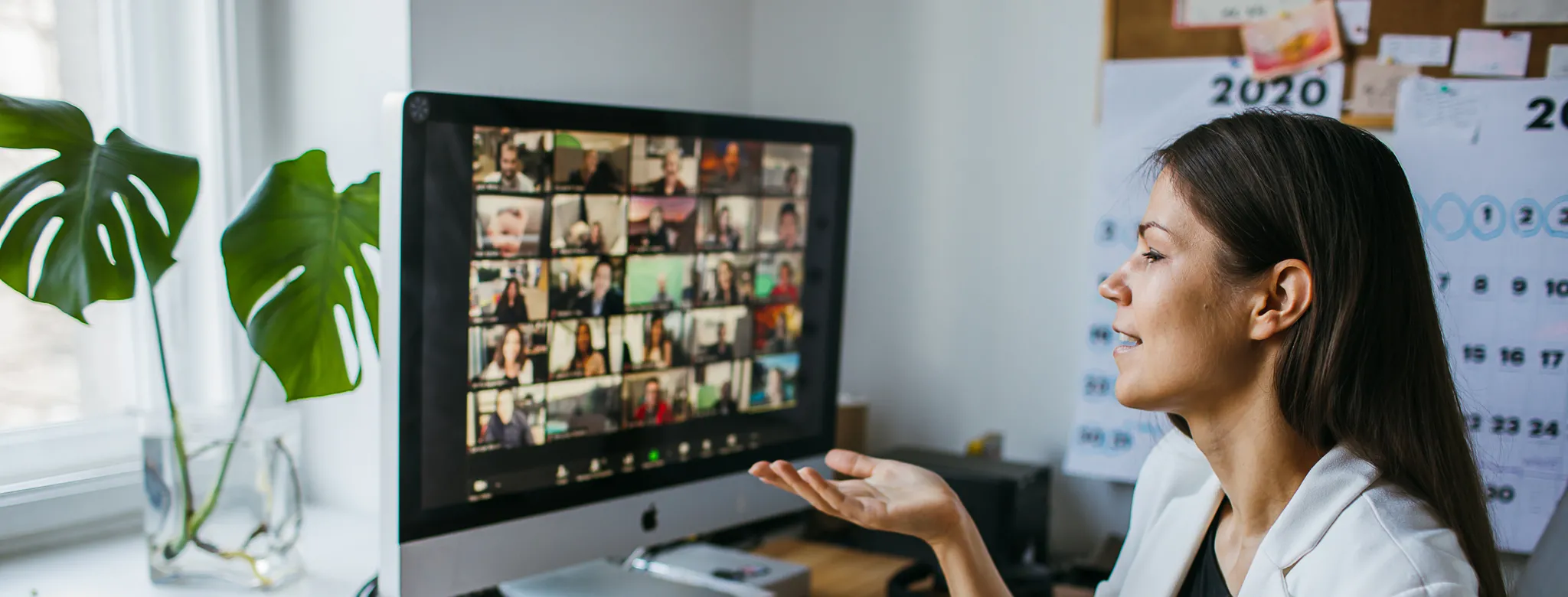 Woman in a blazer in front of a computer on a Zoom meeting