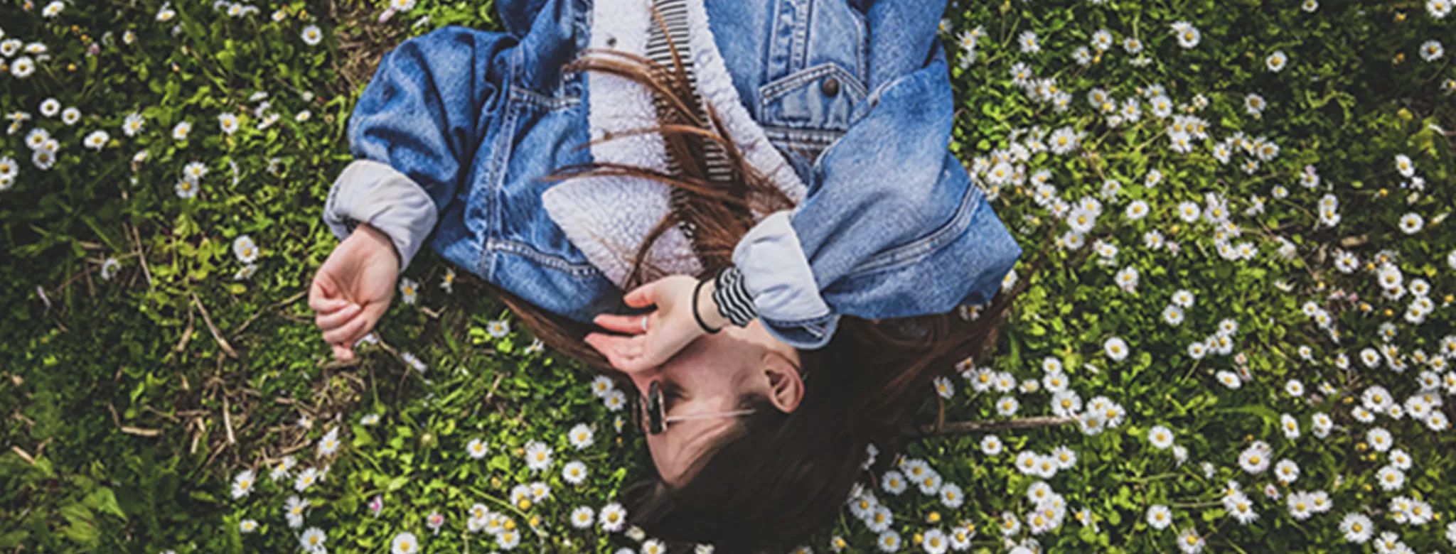 woman laying in field of flowers in spring