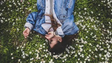 woman laying in field of flowers in spring