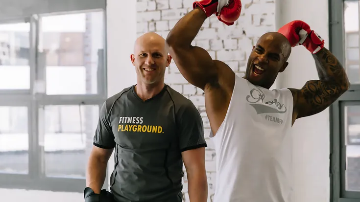 Two men wearing boxing gloves at Fitness Playground