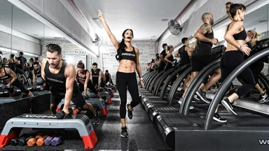A fitness class at Shred 415 featuring weights and treadmills