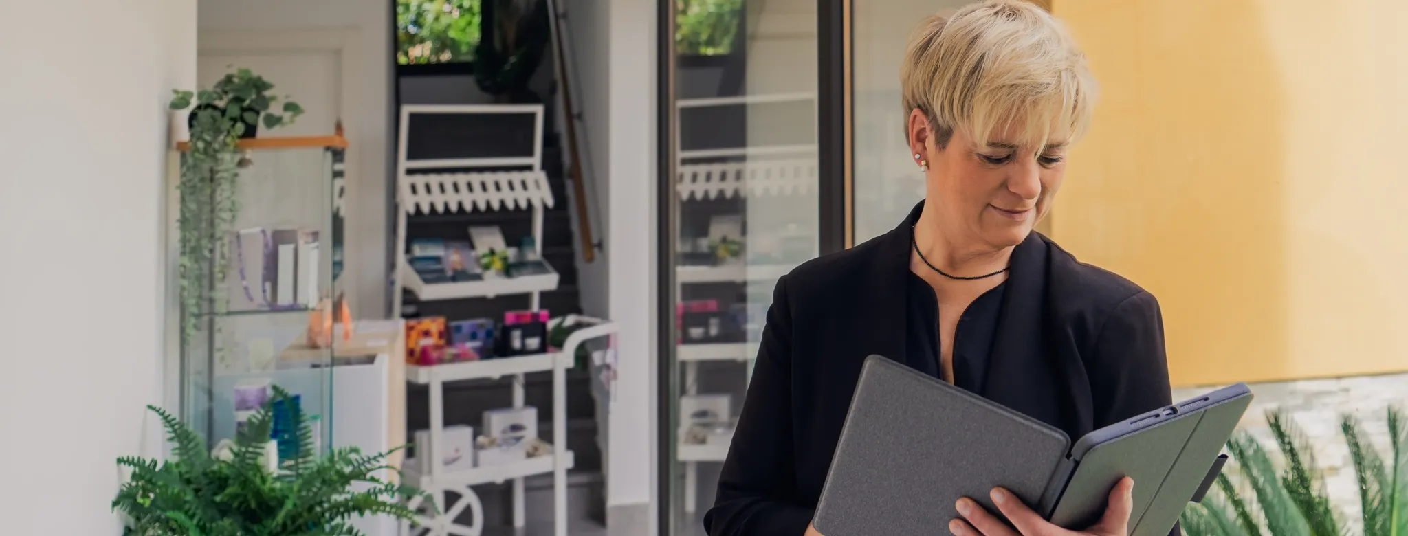 Spa business owner in black shirt looking at financial reports in a black binder