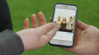 A hand holding a phone showing an image on Instagram