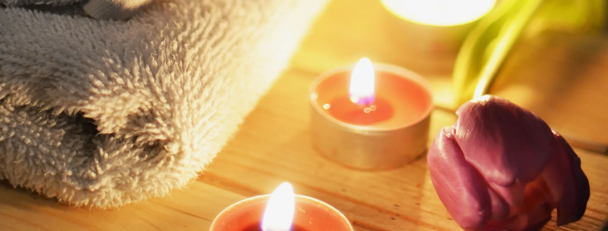 Candles and rose by folded towels