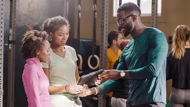Trainer showing tablet to clients