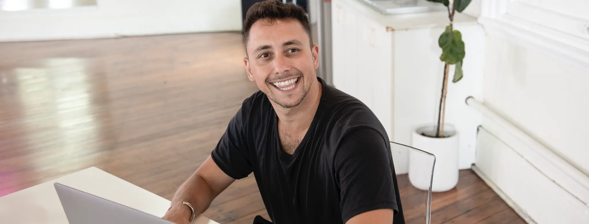 Man smiling at laptop in dance studio