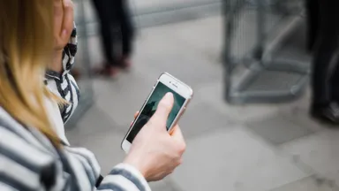 woman in striped shirt checking her phone
