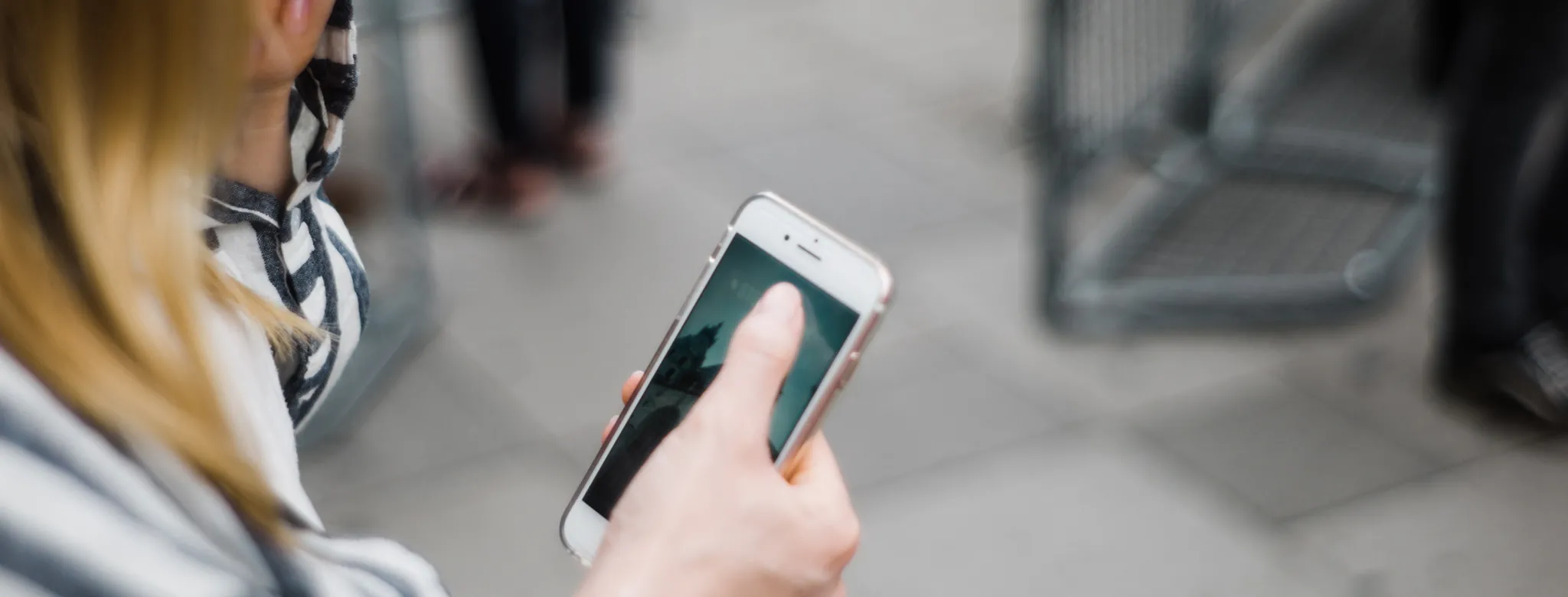 woman in striped shirt checking her phone