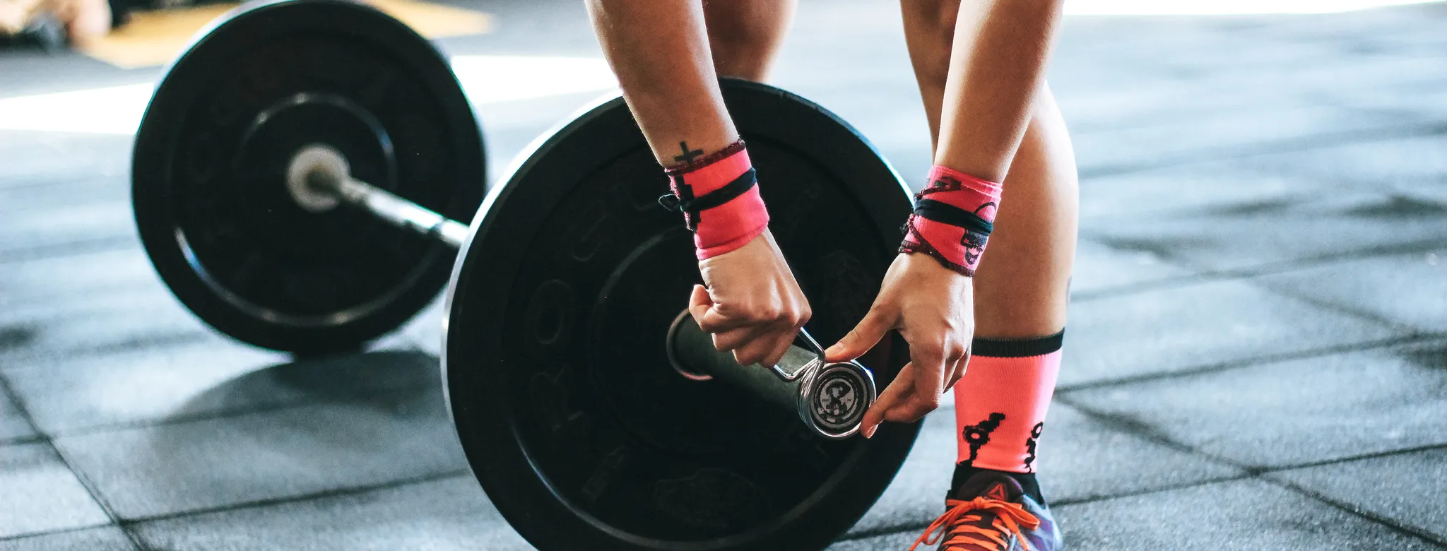 woman adjusting weight on barbell