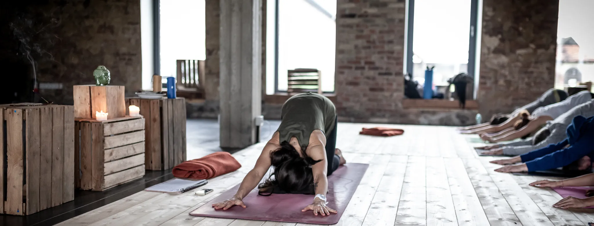 yoga teacher in child's pose in class