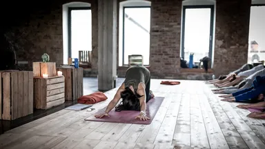 yoga teacher in child's pose in class